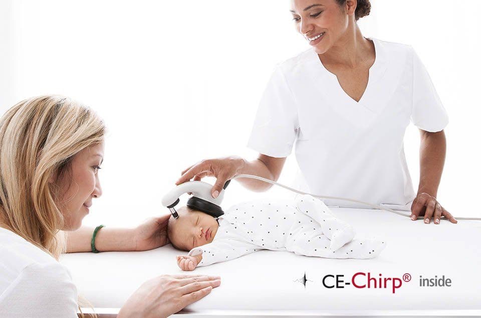Nurse using the MAICO MB 11 BERAphone to test the hearing of a baby while the mother holds the child